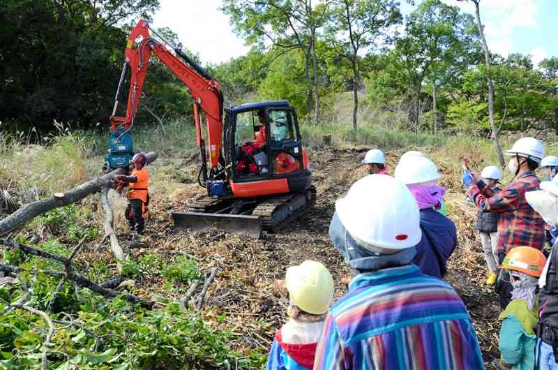 伐採した後、重機で運び出す林業を見学する参加者ら＝南阿蘇村