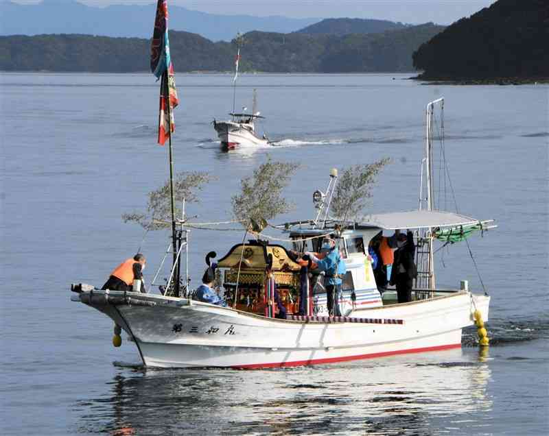 産島（後方右）から上平港へ向かって海を渡るご神体を載せたみこし船＝天草市河浦町