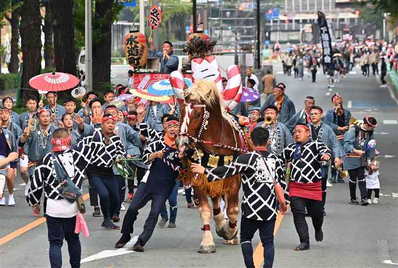 勢子（せこ）のかけ声とともに、勇壮に披露された「馬追い」＝23日午前、熊本市中央区の日銀熊本支店前（後藤仁孝）