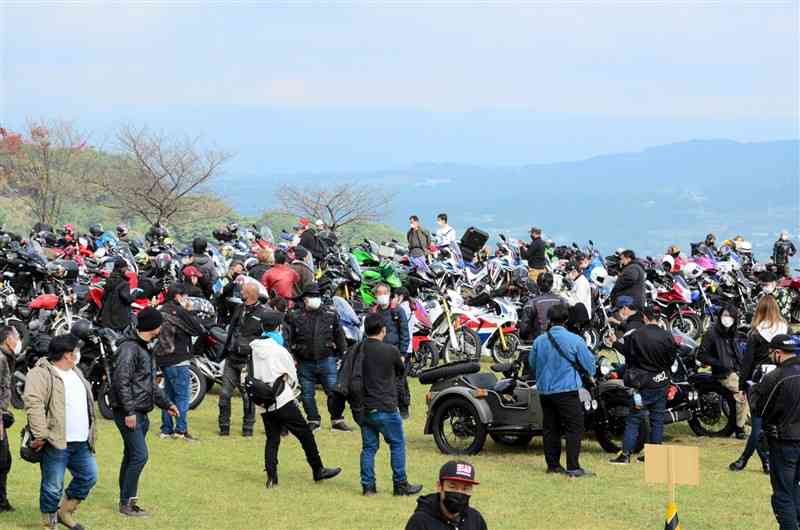 3年ぶりに開催された「ピースライド」で、集まったバイクを眺めながら談笑するライダーたち＝南阿蘇村