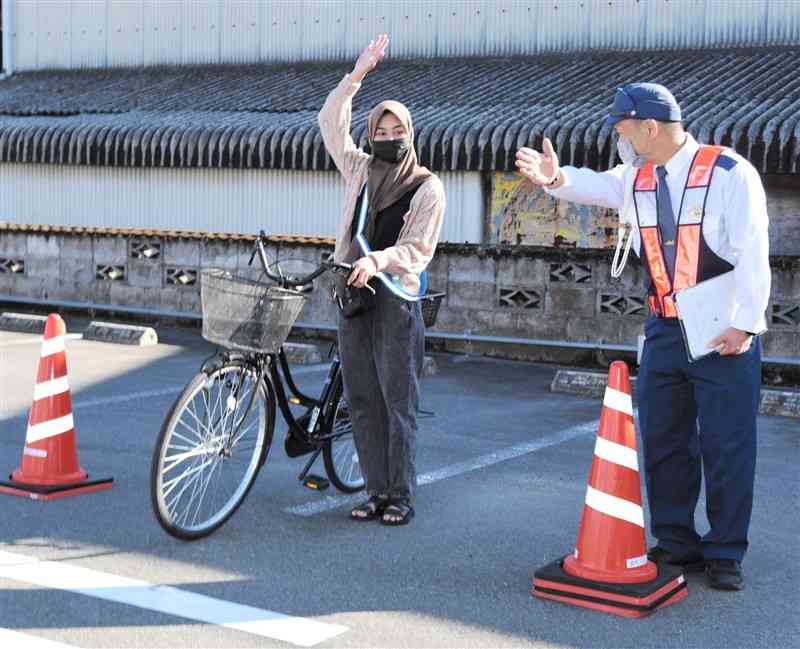 警察官（右）の指導を受け、仮設コースの横断歩道の渡る際に左右の確認をするインドネシア人実習生＝山鹿市