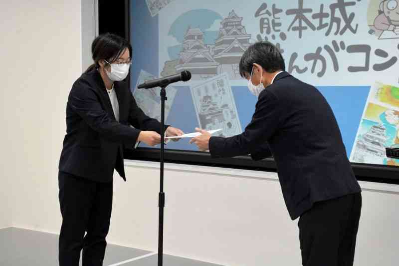 熊本城まんがコンテスト表彰式で、1位の表彰状を受け取る遊木哉吉さん（左）＝30日、熊日本社