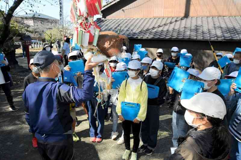 野原八幡宮風流の説明を聞く八幡小の児童＝10月13日、荒尾市