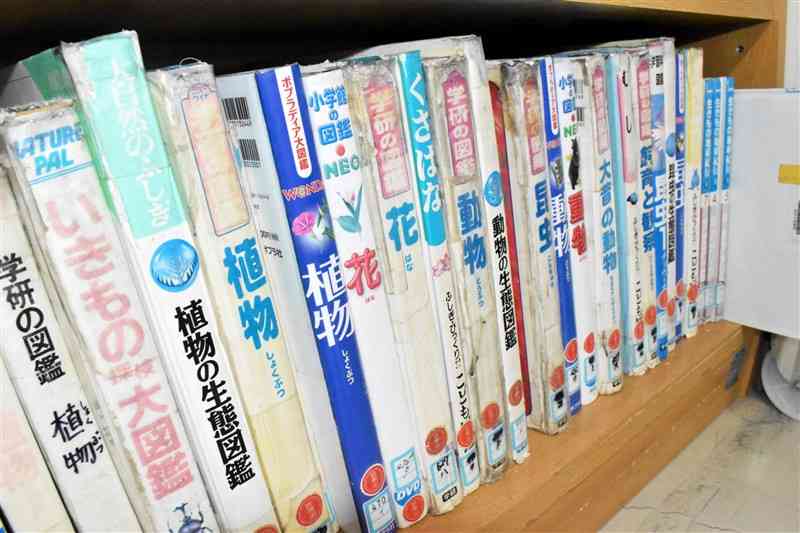 熊本市立託麻西小の図書室の本棚。図鑑や百科事典は補修を重ねながら古いものを使っている＝熊本市東区