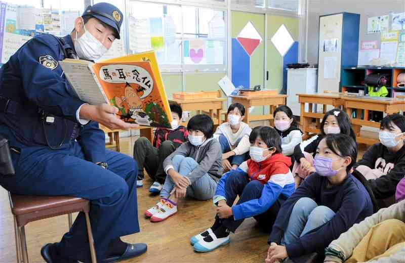 4年生に絵本の読み聞かせをする黒川駐在所の山田貴志巡査長＝南小国町のりんどうケ丘小