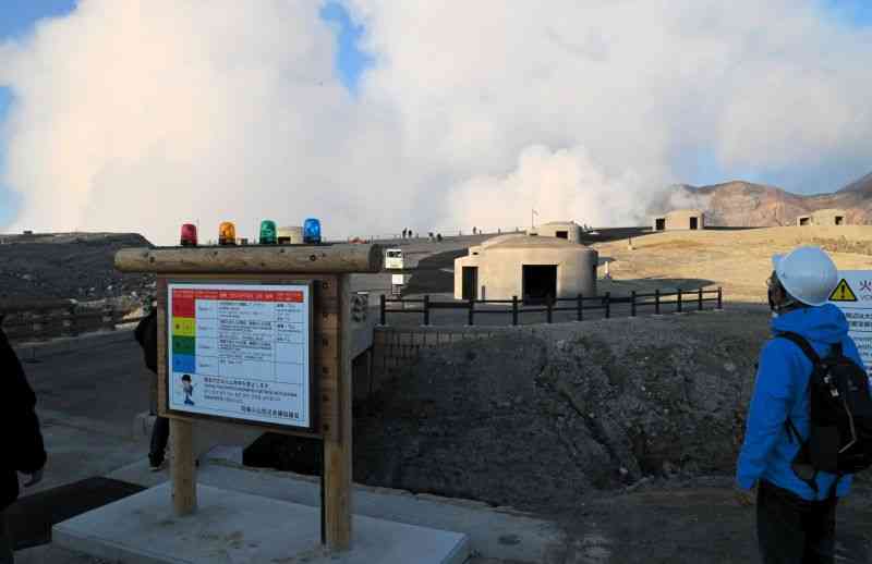 ガス濃度の警報器（手前）や退避壕などが建て直された中岳火口見学エリア＝7日午後5時ごろ、阿蘇市