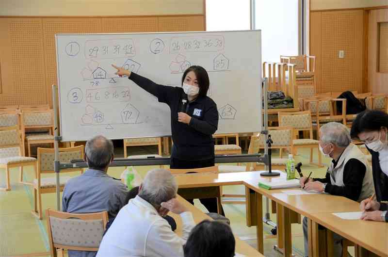 認知症予防教室で問題を出す吉田良子さん（中央）＝菊池市