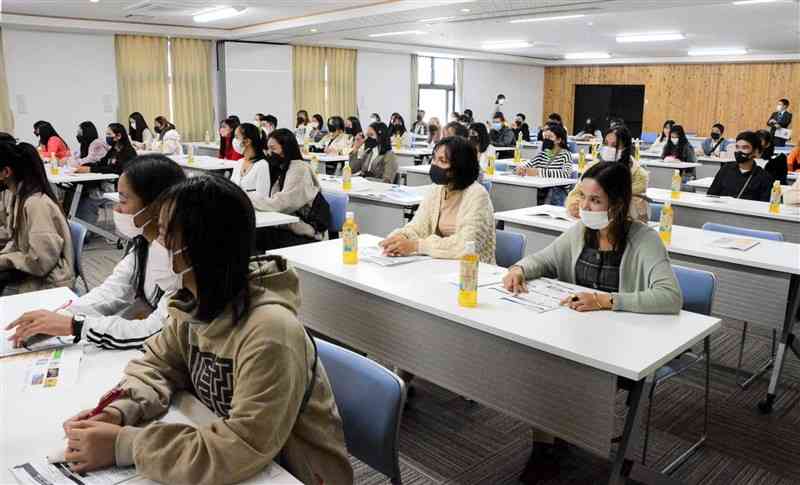 熊本の農業や文化を紹介する動画を熱心に視聴するカンボジア人の参加者たち＝10日、合志市