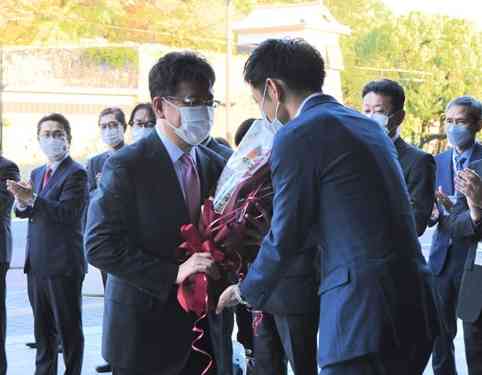 熊本市長選後の初登庁で、出迎えた職員から花束を受け取る大西一史市長（左）＝14日、同市役所