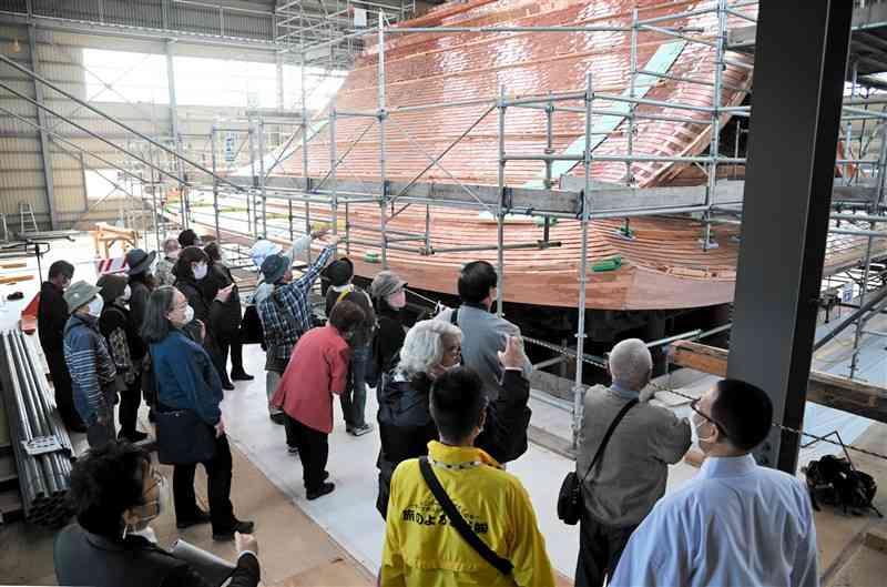 復旧工事が進む阿蘇神社楼門の上層部を見学する参加者ら＝27日、阿蘇市