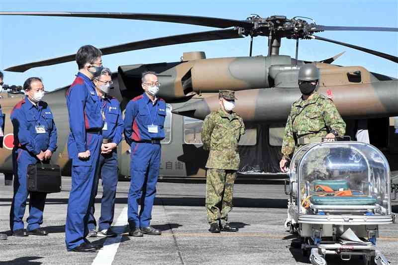 陸上自衛隊から災害時のヘリコプターの運用方法などを学ぶ県職員＝28日、益城町