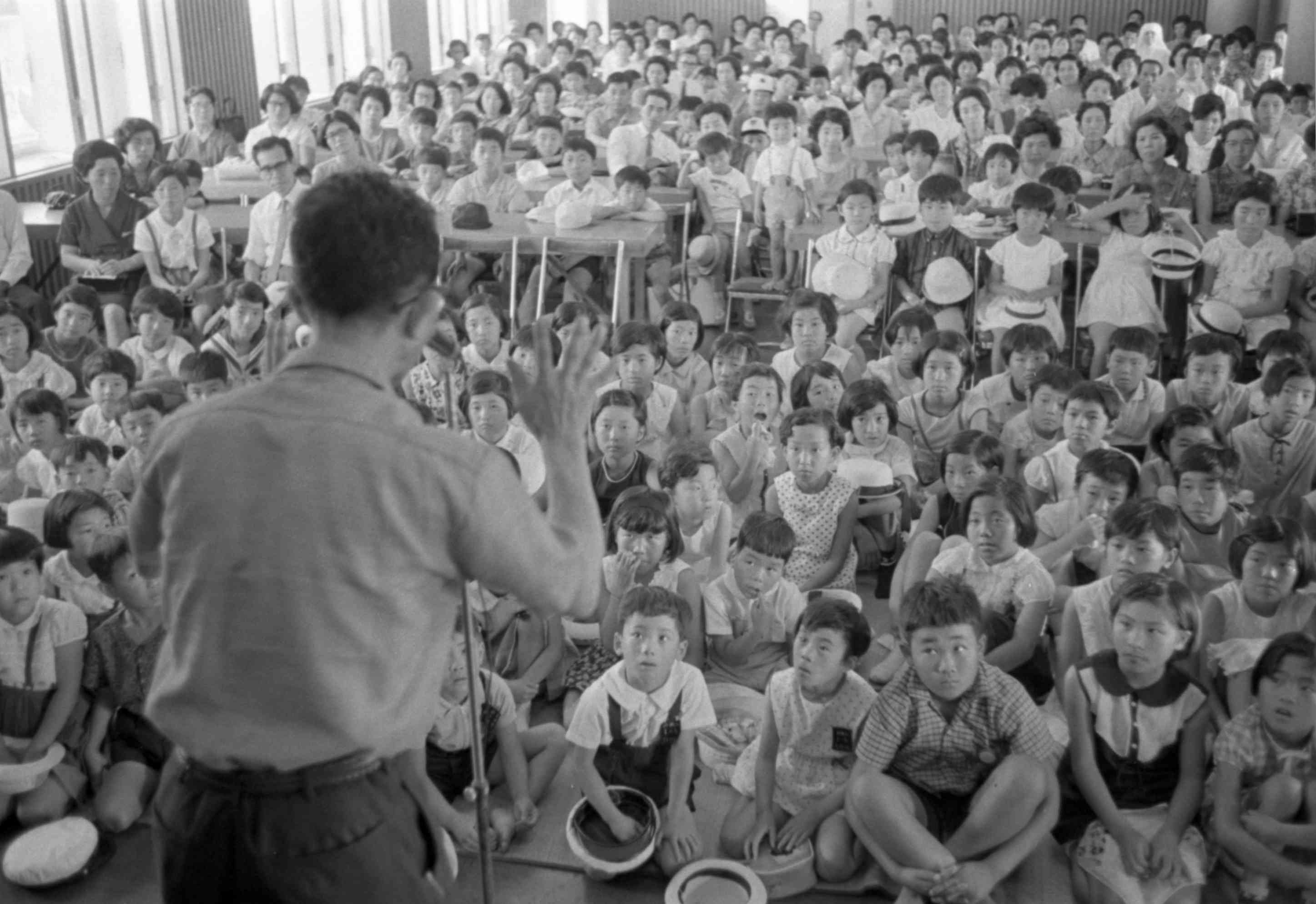 熊日童話会の15周年記念講演会で、口演童話を熱心に聞く子どもたち＝1967年、熊本市上通町の熊日本社