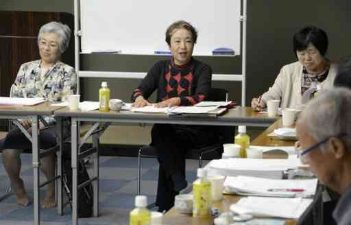 創作教室受講者の作品を講評する講師の今関信子さん（中央）と筆者（右）＝2014年、熊本市