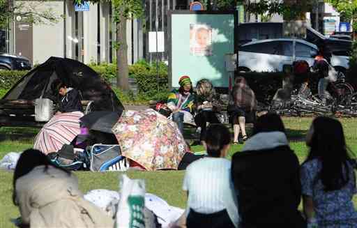 避難所となった白川公園で朝を迎えた人たち＝2016年4月16日午前8時ごろ、熊本市（横井誠）