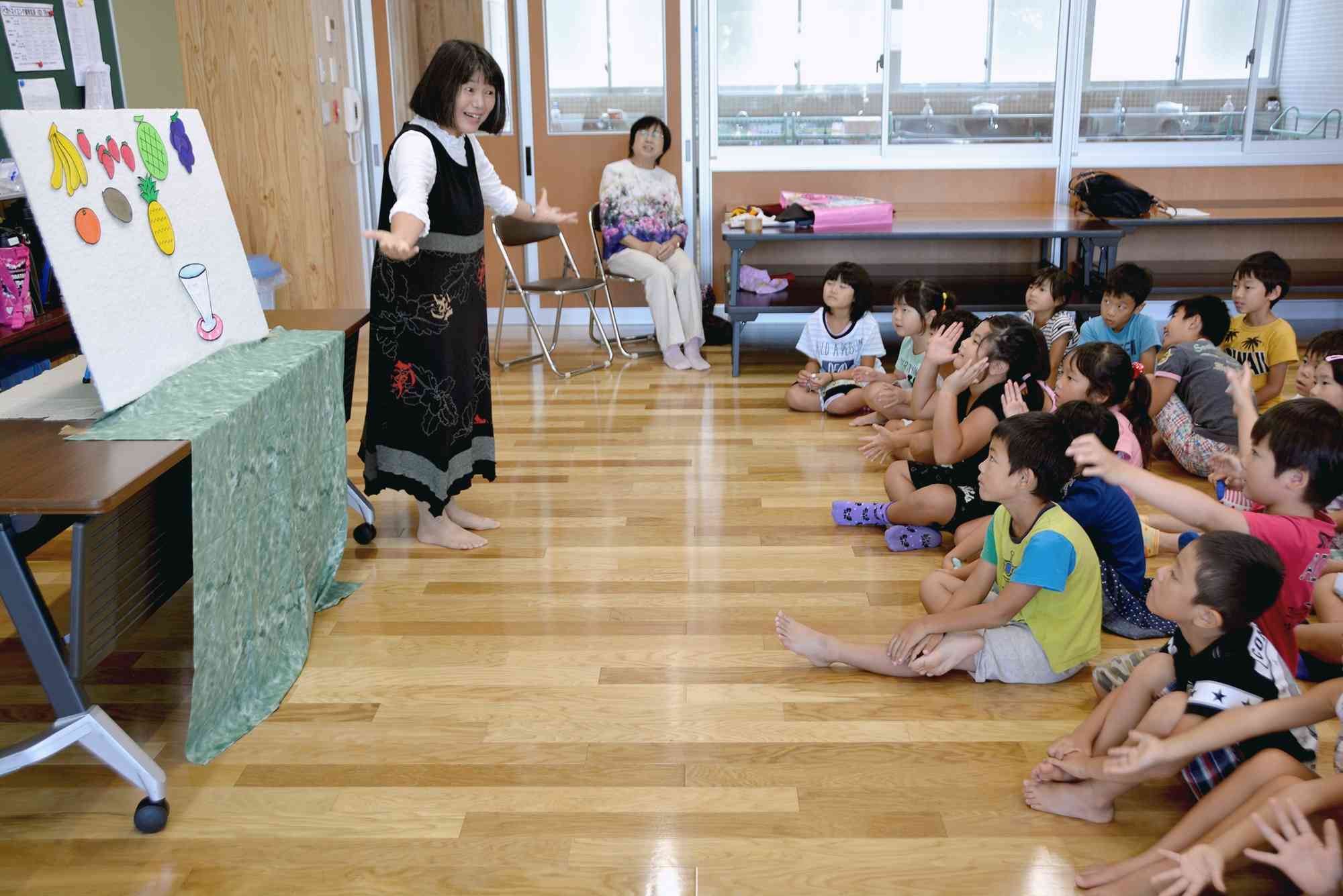 熊本地震後、初めて子どもたちにお話を届けた吉永千草さん（左）＝2016年8月、嘉島町の嘉島西小