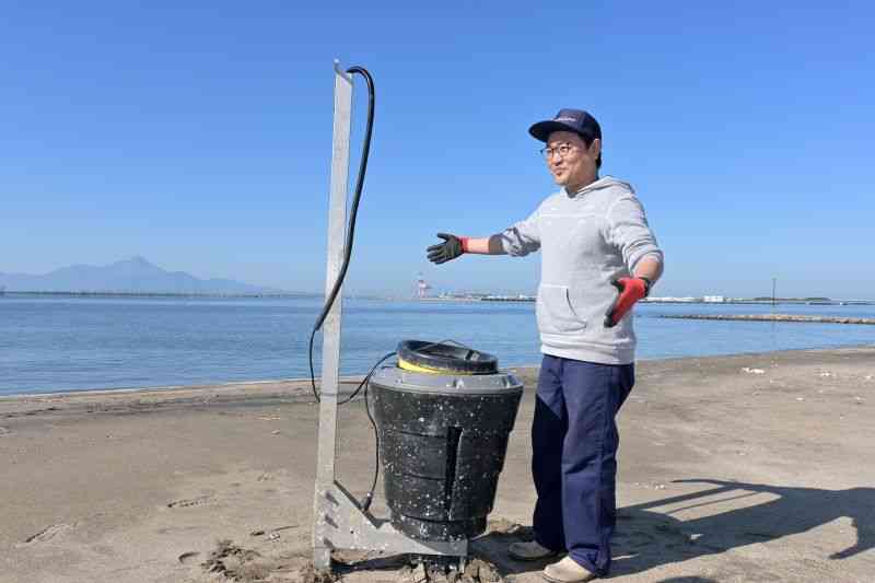 海を漂流するプラごみなどを自動回収する「シービン」を前に「きれいな海を残したい」と話す東濵孝明さん＝熊本市西区（谷川剛）