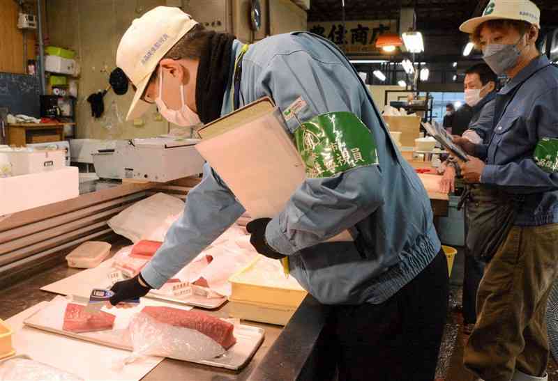 熊本地方卸売市場（田崎市場）で魚介類の管理されている温度を測る食品衛生監視員ら＝1日、熊本市西区