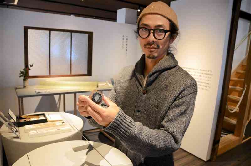 木工スタンプを受注制作する小山田将監さん＝熊本市中央区