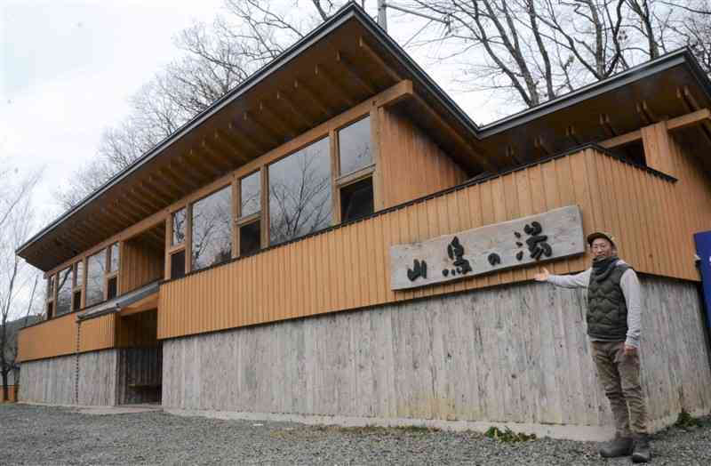 キャンプ場内に再建した温泉棟を案内する井聡也さん＝南小国町