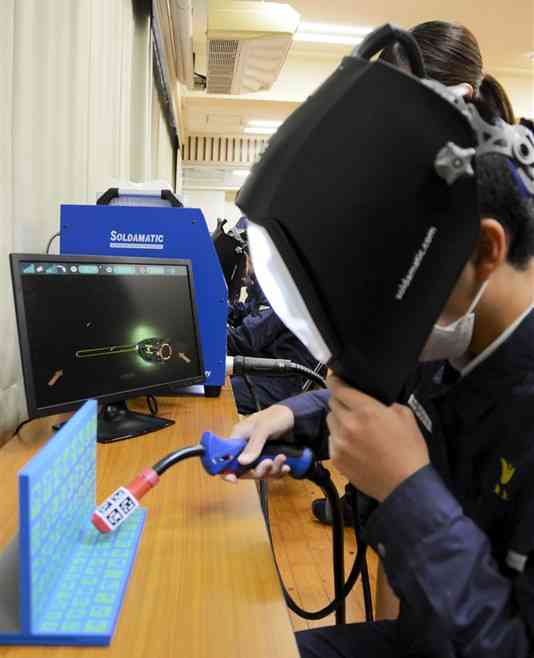 拡張現実（AR）を使った溶接訓練を体験する生徒ら＝八代市