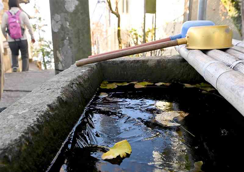 氷が張った金峰山神社のちょうず鉢＝15日午前8時25分ごろ、熊本市西区