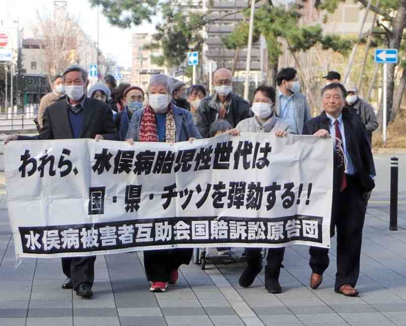横断幕を掲げ、入廷する水俣病被害者互助会の原告ら＝20日、福岡市