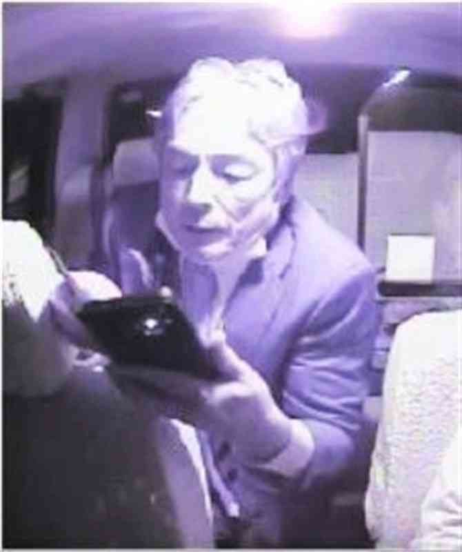 ドライブレコーダーに記録された井手順雄県議の映像（タクシー会社提供）。後部座席から身を乗り出し、スマートフォンで運転者証を撮影している