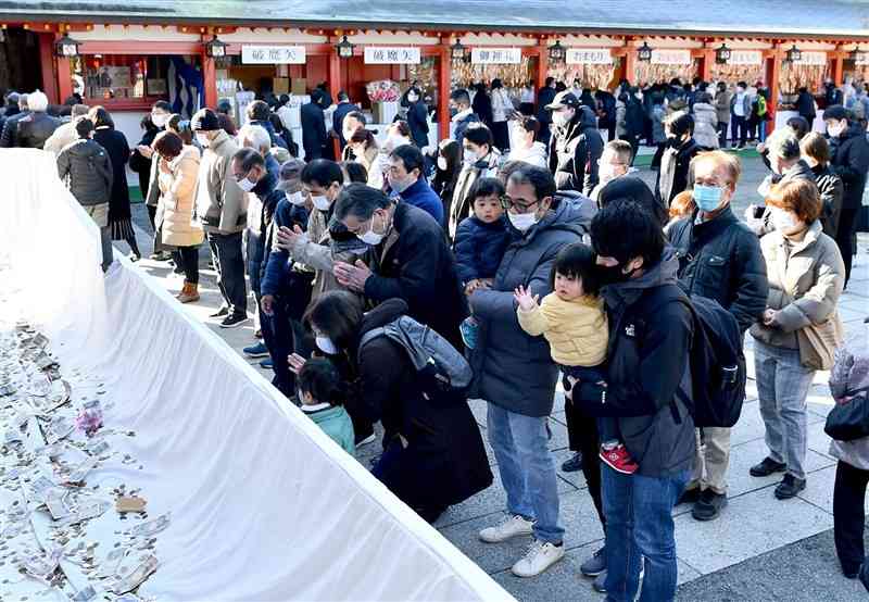 2022年の元日、多くの初詣客が訪れた熊本市中央区の藤崎八旛宮。さい銭箱には大量の硬貨や紙幣が集まっている（石本智）