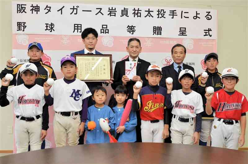 益城町の野球少年らと写真に納まる岩貞祐太投手（後列左から2人目）＝同町