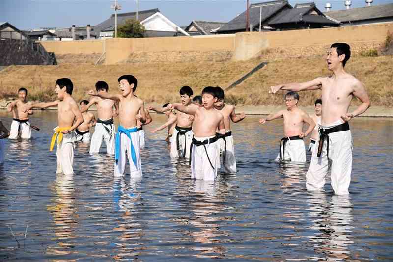 菊池川に入って、突きをする小中学生ら＝山鹿市