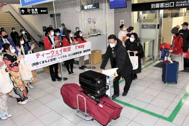 ティーウェイ航空のソウル定期便が再開し、熊本空港で県職員らの出迎えを受ける韓国からの観光客＝5日、益城町