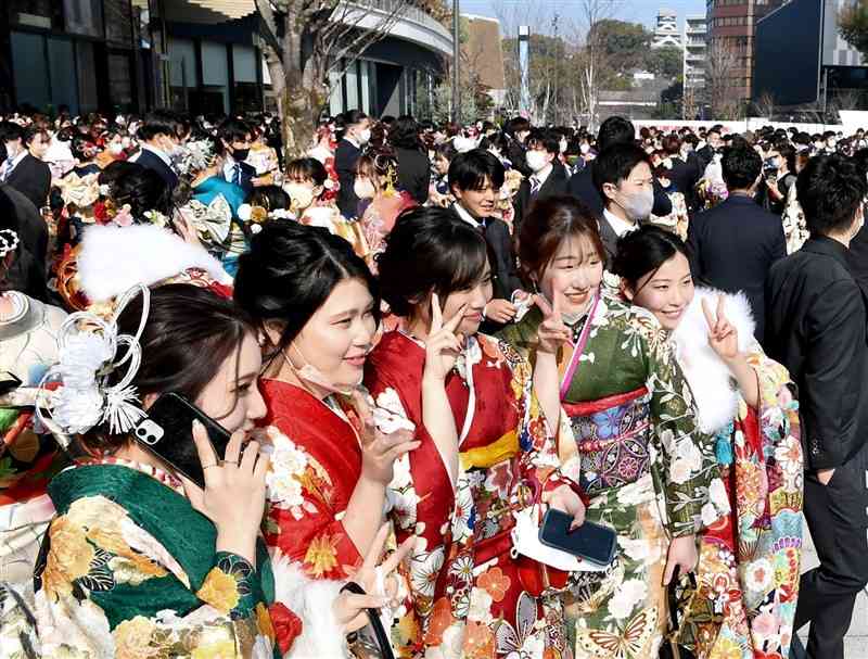 昨年の熊本市の成人式で、記念撮影する新成人たち。成人年齢が引き下げられた今年も引き続き、「20歳」を対象としている＝2022年1月、中央区の花畑広場（石本智）