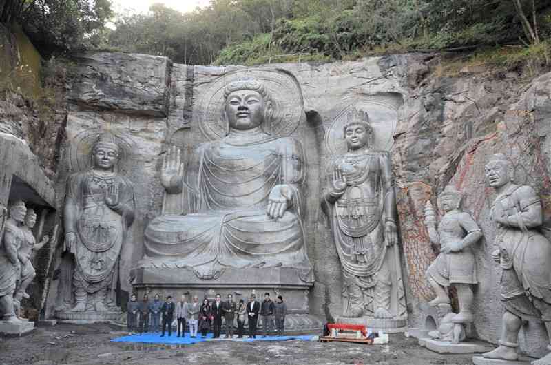 ネパールから招いた仏像彫刻家らの手で完成が近づく7体の磨崖仏＝上天草市