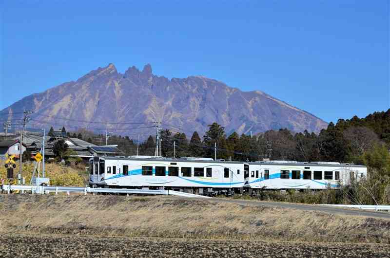 根子岳を背景に2両編成で走る南阿蘇鉄道の新型車両「MT4000形」＝南阿蘇村
