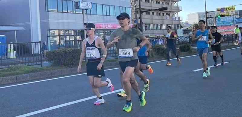 青島太平洋マラソンで、宮崎市内を走る岡本遼記者（左）