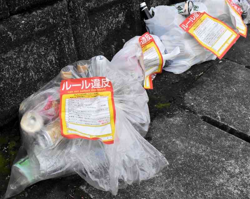 「ルール違反」のシールが貼られたごみ袋＝2022年12月下旬、熊本市