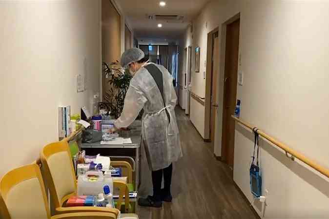 有料老人ホーム「まごころの家」で、防護服を着て新型コロナウイルスに感染した入居者に対応する職員＝熊本市北区（まごころの家提供）