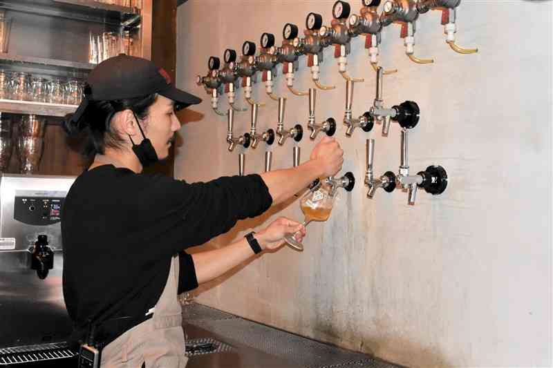 ダイヤモンドブルーイングが運営するレストランでビールを注ぐスタッフ＝20日、熊本市中央区
