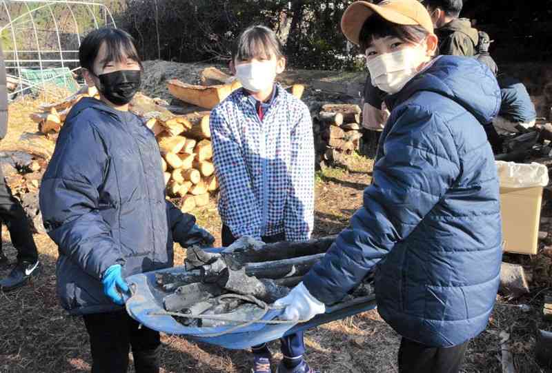 出来上がった炭を窯から運び出す子どもたち＝菊池市