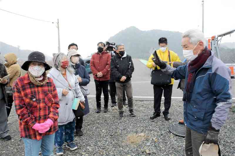 JR肥薩線沿線を巡るツアーで、豪雨被災者の東研志さん（右）の話を聞く参加者＝球磨村