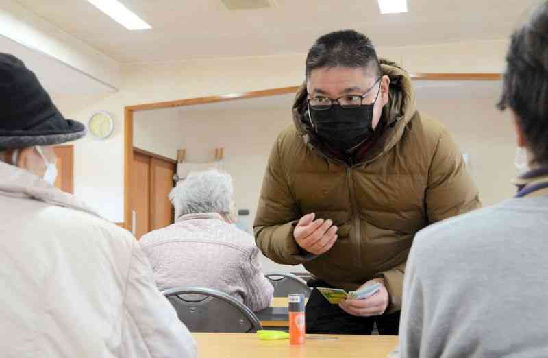 町内の住民に自己紹介する民生委員の尾下修一さん＝昨年12月、熊本市北区