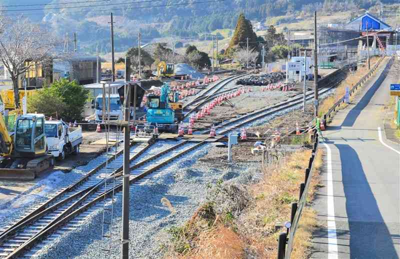 南阿蘇鉄道のレールとJR豊肥線のレールの接続工事が進む立野駅周辺。右奥は新設工事が進む新駅舎＝1月、南阿蘇村