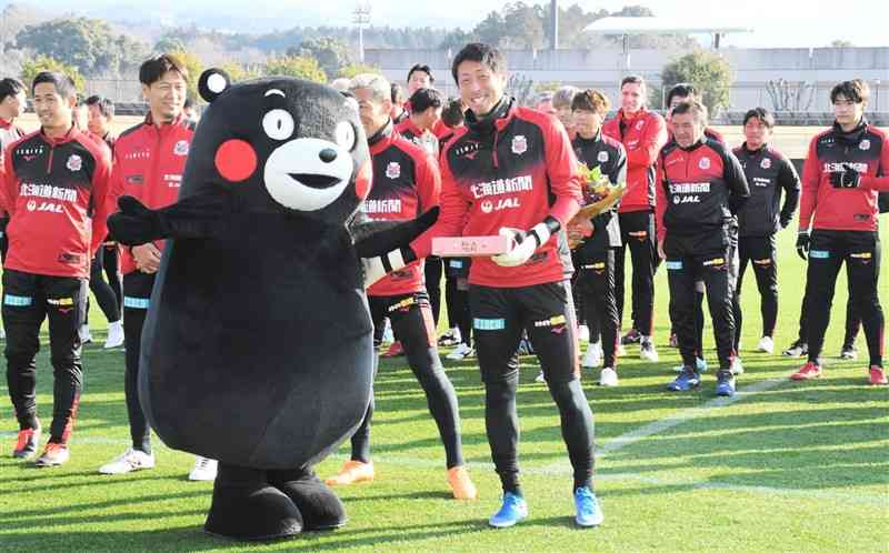 くまモンから県産イチゴを贈られるコンサドーレ札幌のGK大谷幸輝（中央）ら＝8日、大津町運動公園