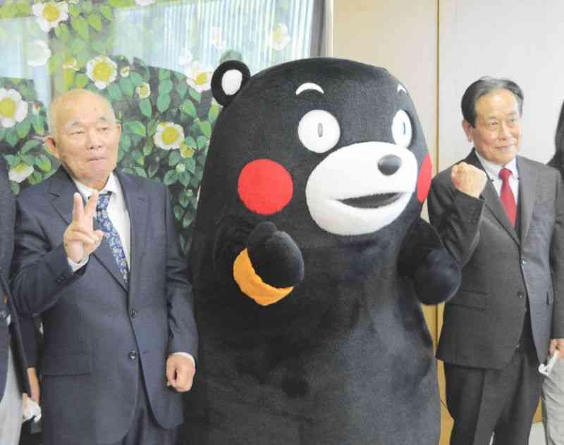 「くまもとオレンジ大使」に任命され、くまモンと記念撮影する田中壮さん（左）と松本力さん＝8日、県庁