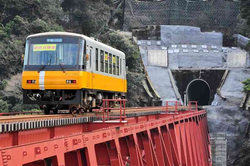 レール締結式を終え、新たに架け替えられた第一白川橋梁を渡る保守点検車両＝南阿蘇村