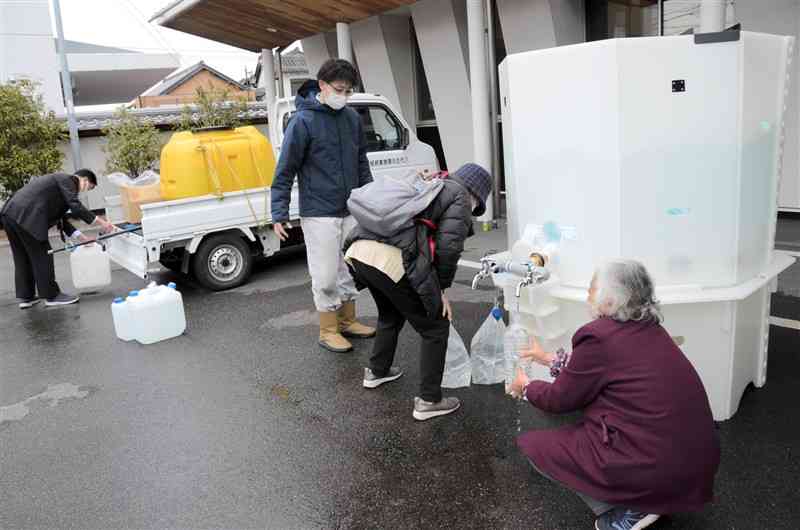 氷川町宮原振興局の応急給水所。給水袋やペットボトルを持参した町民が次々と訪れた＝9日、同町