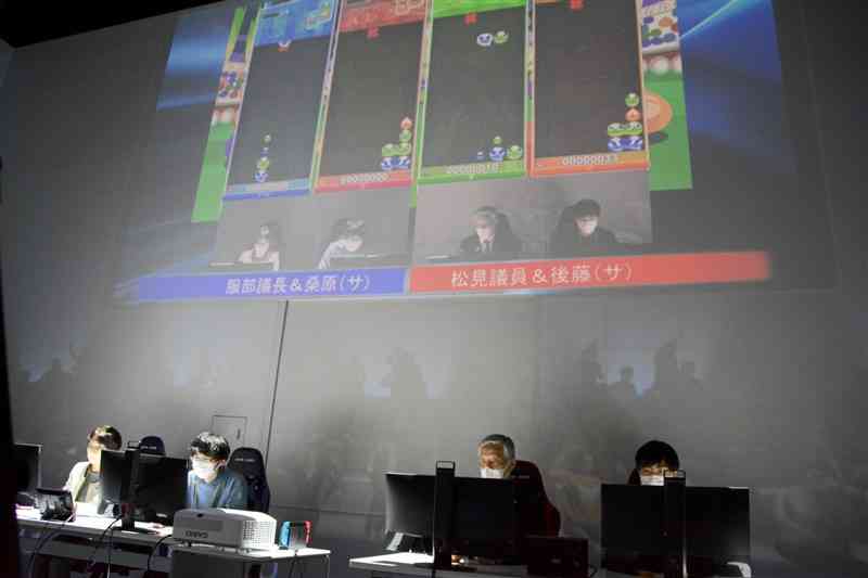 eスポーツで対戦する山鹿市議と学生ら＝10日、熊本市西区