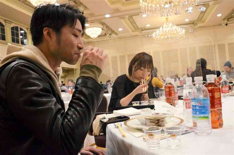 球磨焼酎などの蒸留酒を、ご当地グルメと一緒に味わう参加者＝14日、東京