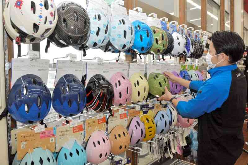 自転車販売店のヘルメット売り場＝14日、熊本市南区