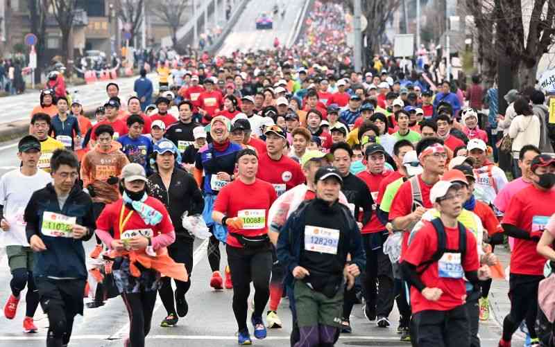 <h4>まだまだ余裕？</h4>10キロ過ぎでコースを埋めるフルマラソンのランナーたち＝熊本市南区